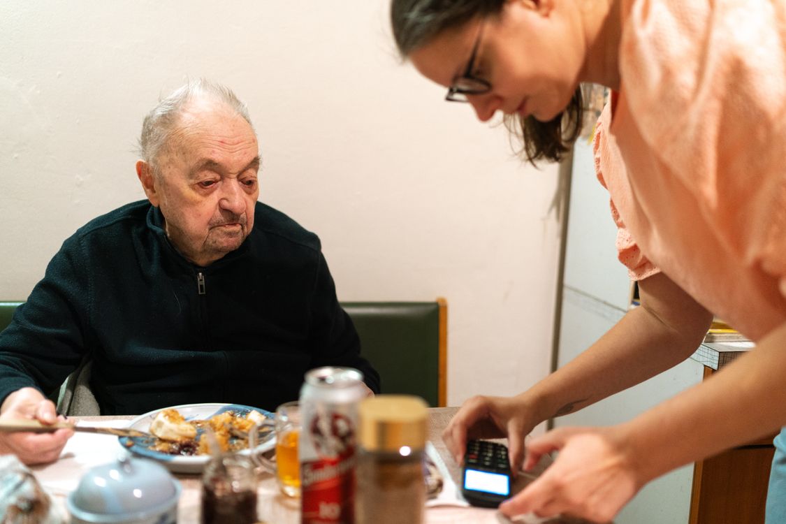 Caregiver assisting an older adult during a meal