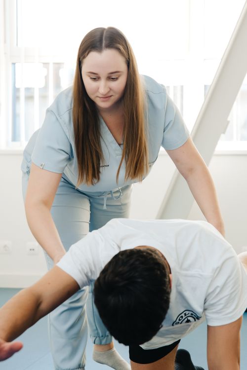 Physical therapist guiding a patient through a supported exercise